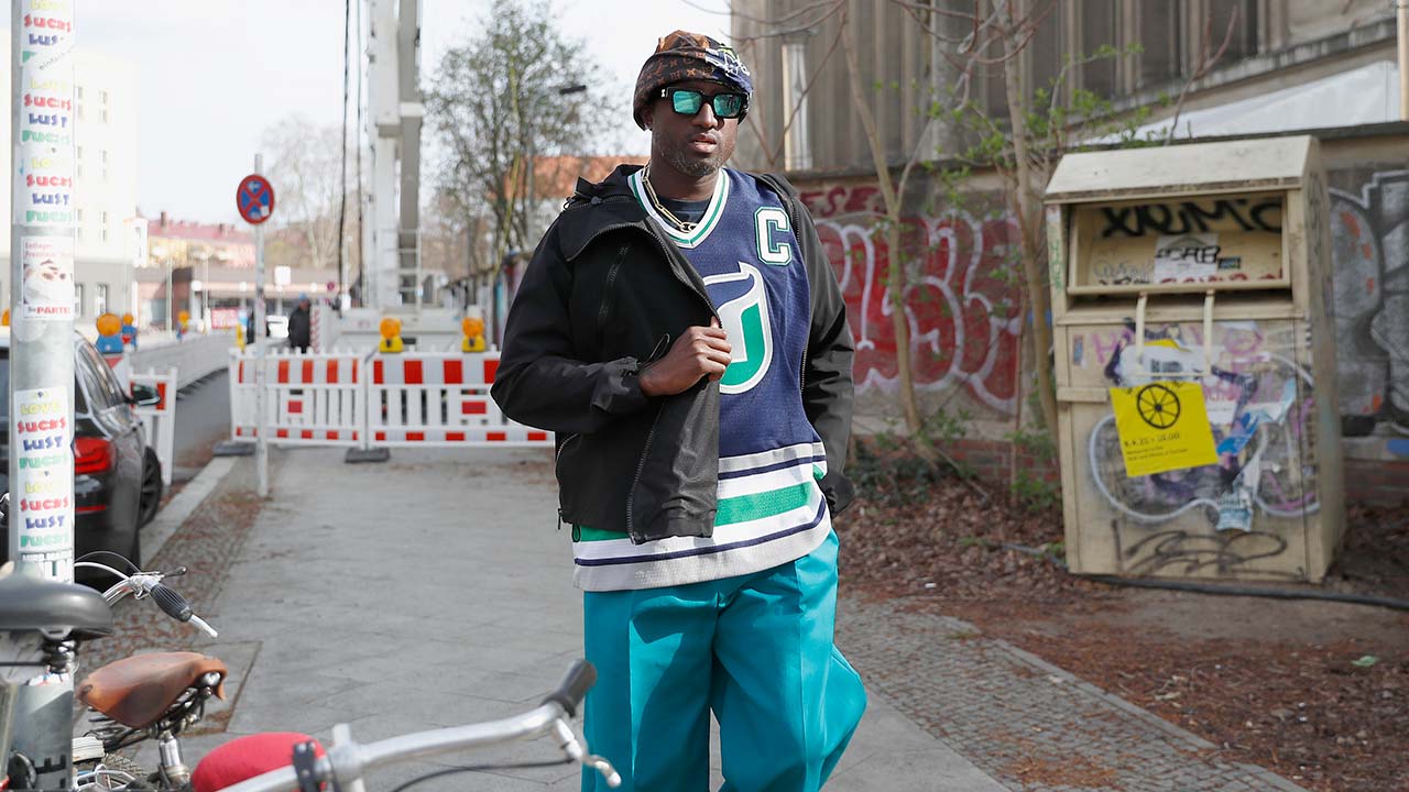 Virgil Abloh in a silly hat, sunglasses, Hartford Whalers jersey, and bright blue painters pants