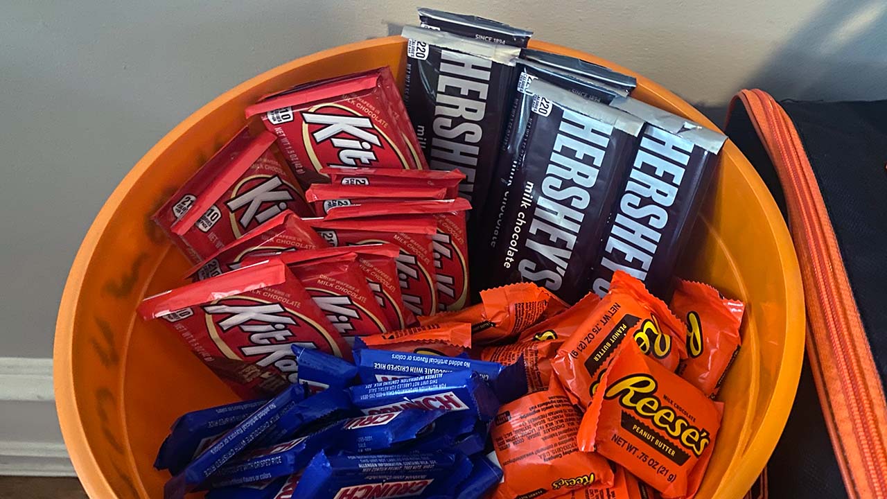 A bowl of candy. It's orange. It has a bunch of regular-sized Hershey and Kit Kat bars in it.