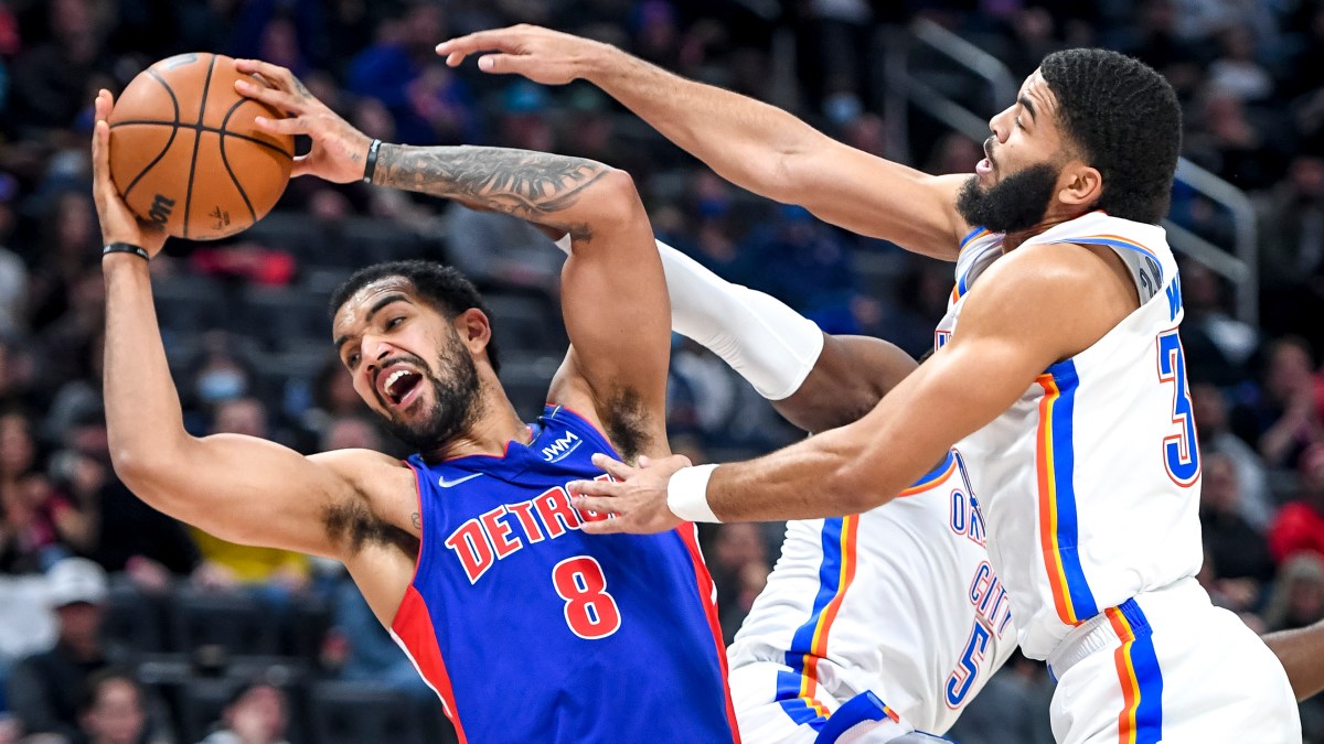 Trey Lyles #8 of the Detroit Pistons grabs a rebound against Luguentz Dort #5 and Kenrich Williams #34 of the Oklahoma City Thunder during the fourth quarter at Little Caesars Arena on December 06, 2021 in Detroit, Michigan.