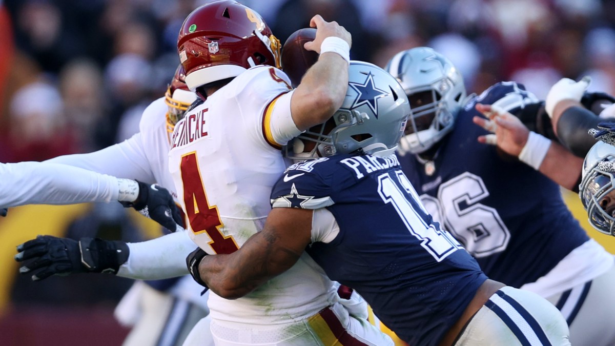 Micah Parsons #11 of the Dallas Cowboys forces Taylor Heinicke #4 of the Washington Football Team to fumble and is returned for a touchdown by Dorance Armstrong #92 (not pictured) during the first quarter at FedExField on December 12, 2021 in Landover, Maryland.