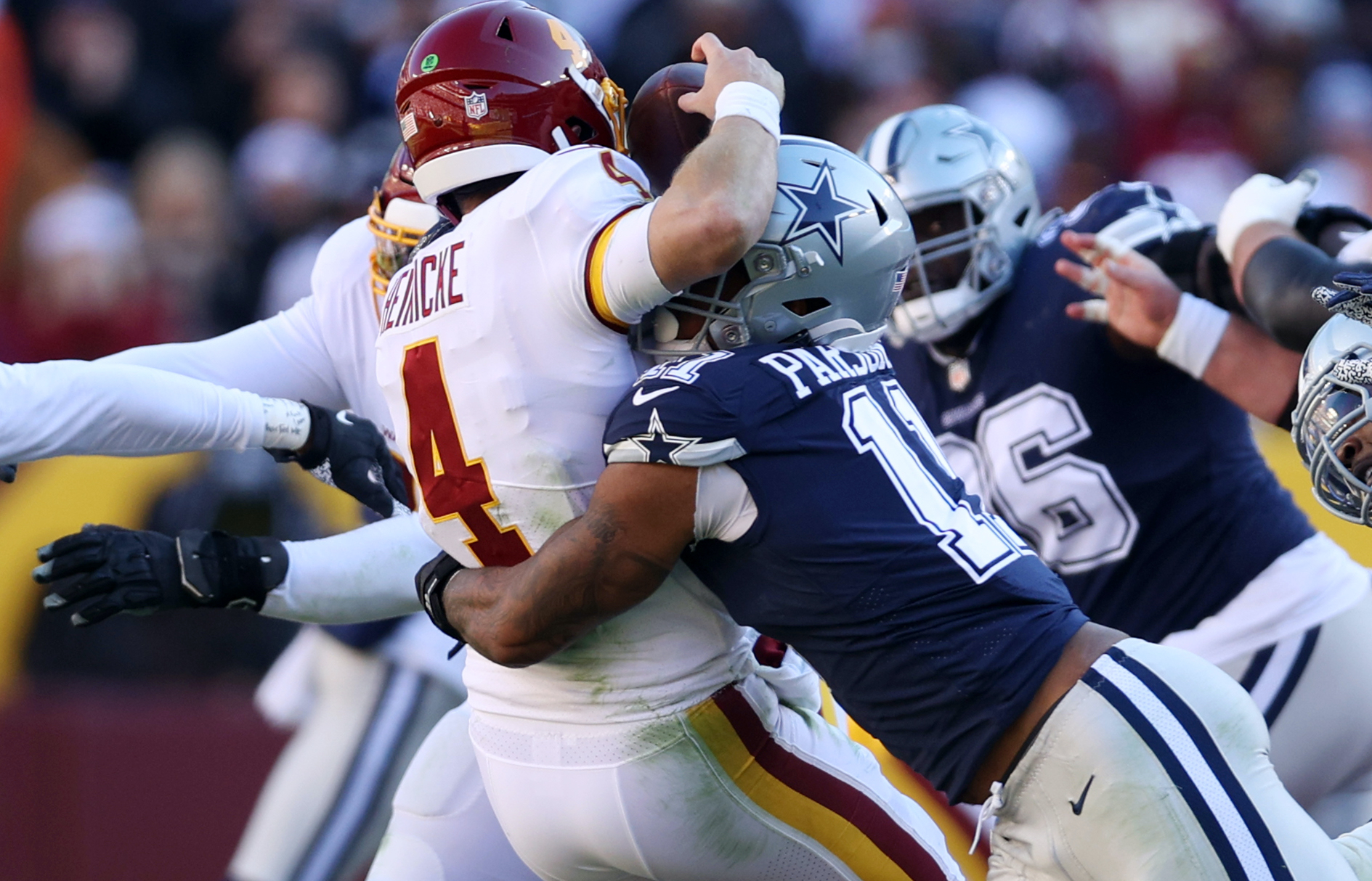 Micah Parsons #11 of the Dallas Cowboys forces Taylor Heinicke #4 of the Washington Football Team to fumble and is returned for a touchdown by Dorance Armstrong #92 (not pictured) during the first quarter at FedExField on December 12, 2021 in Landover, Maryland.