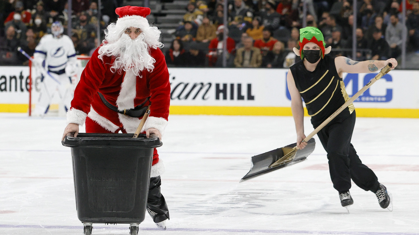 LAS VEGAS, NEVADA - DECEMBER 21: A member of the Knights Guard dressed as Santa Claus and another wearing an elf hat clean the ice during the Vegas Golden Knights' game against the Tampa Bay Lightning at T-Mobile Arena on December 21, 2021 in Las Vegas, Nevada. The Lightning defeated the Golden Knights 4-3. (Photo by Ethan Miller/Getty Images)