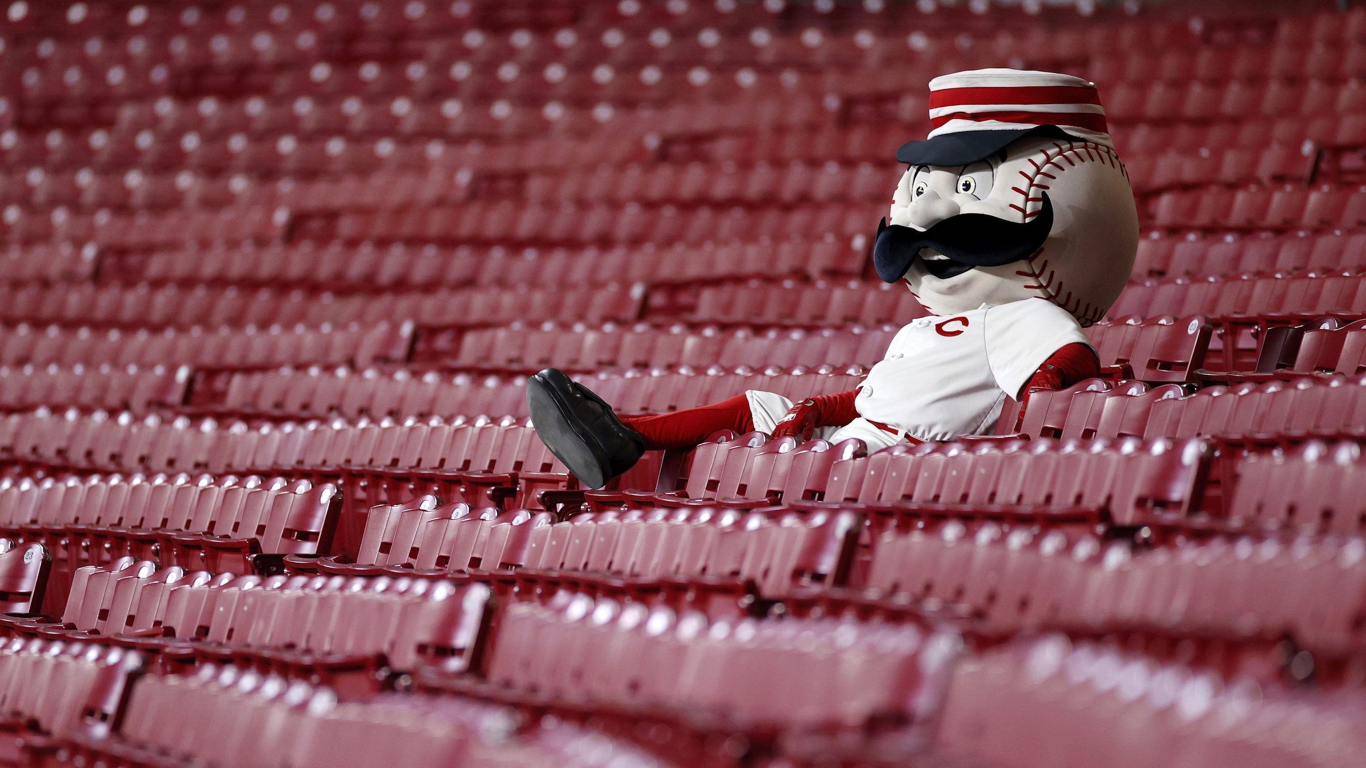 Cincinnati Reds mascot Mr. Redlegs sits in the empty stands.