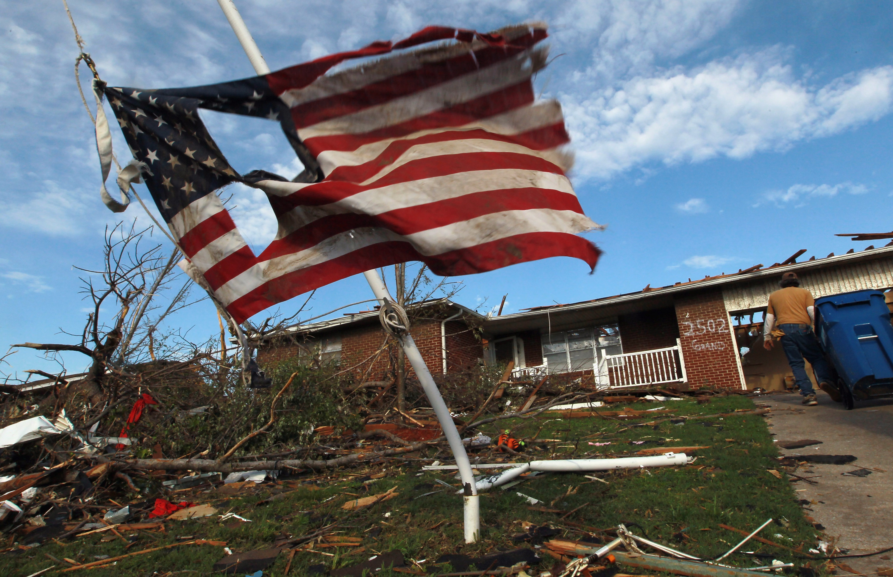 A tattered American flag flies outside a tornado-damaged home in Joplin, Missouri.