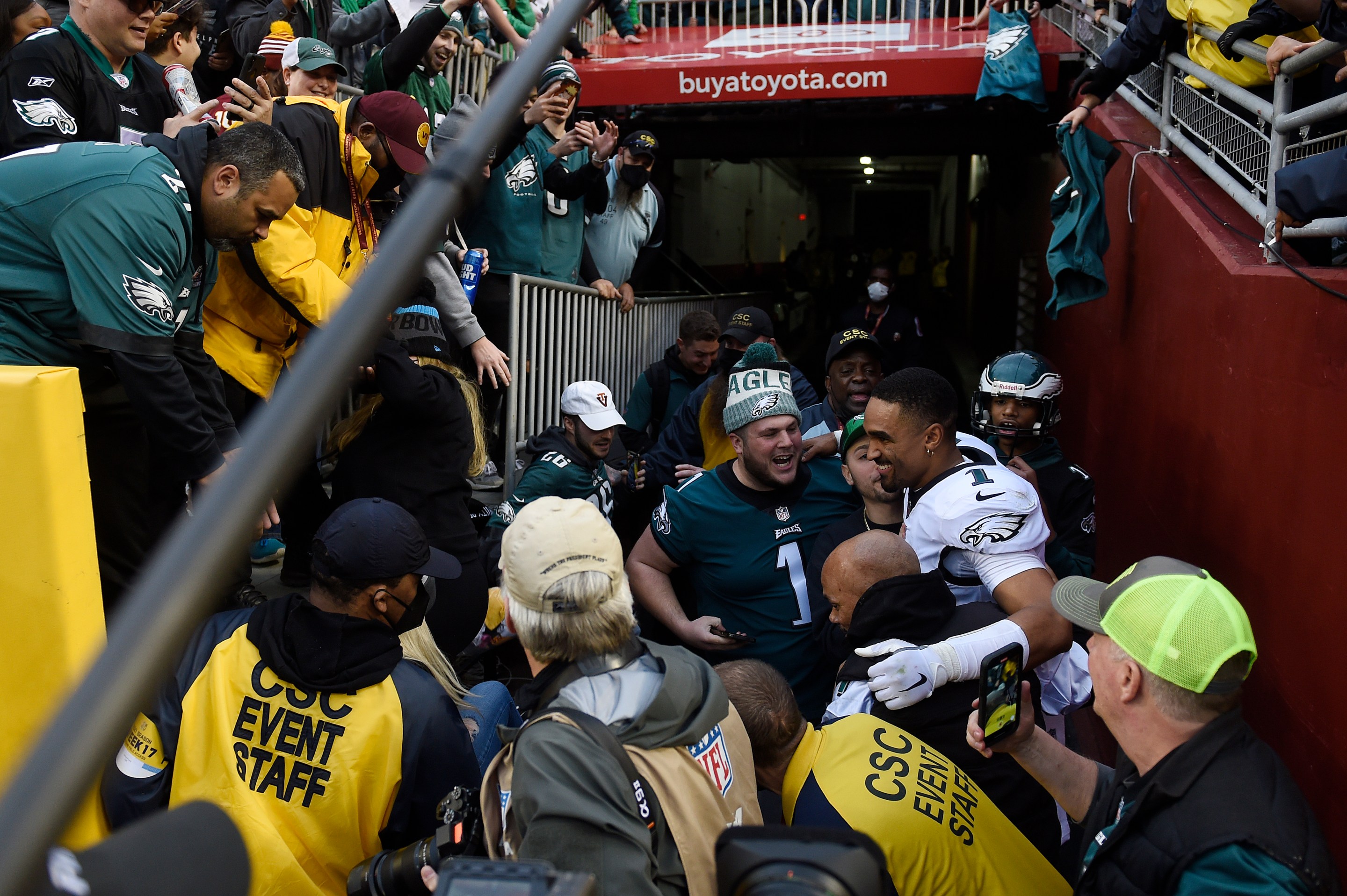 Jalen Hurts celebrates with fans who fell onto the ground after a railing collapsed