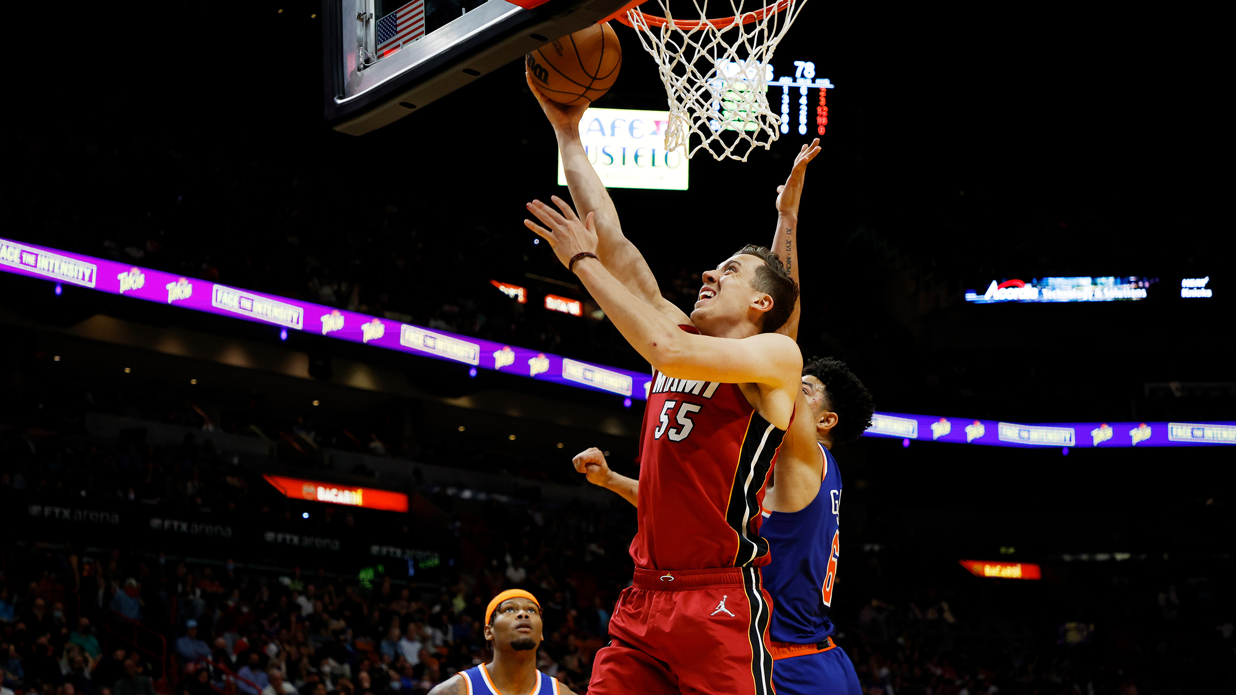 Duncan Robinson #55 of the Miami Heat shots against Quentin Grimes #6 of the New York Knicks at FTX Arena on January 26, 2022 in Miami, Florida.