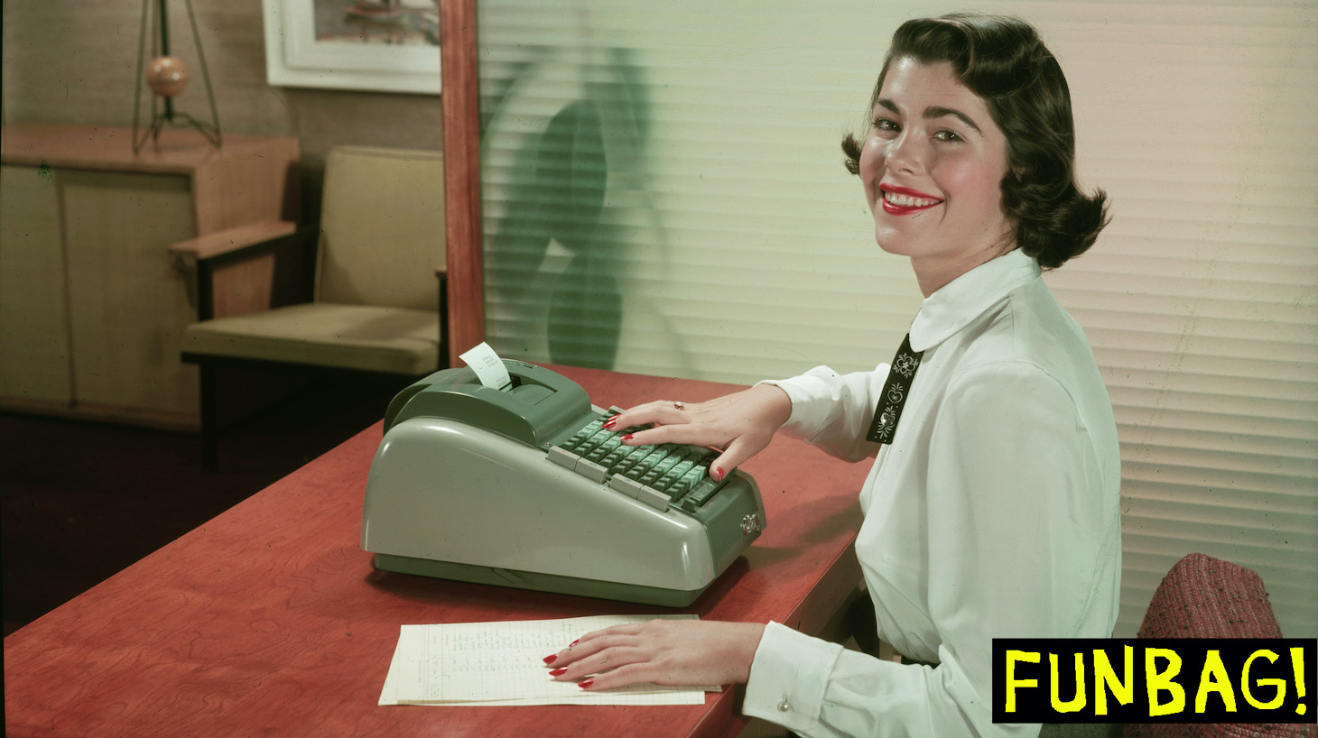 A young woman smiles as she poses at a desk in an office-like environment, one hand on a document and the other on the keys of a Clary adding machine, mid to late 1950s. (Photo by Tom Kelley/Getty Images)