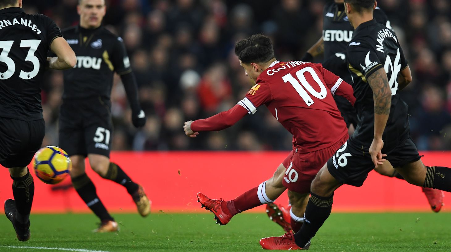 Liverpool's Brazilian midfielder Philippe Coutinho (C) shoots to score the opening goal of the English Premier League football match between Liverpool and Swansea City at Anfield in Liverpool, north west England on December 26, 2017.