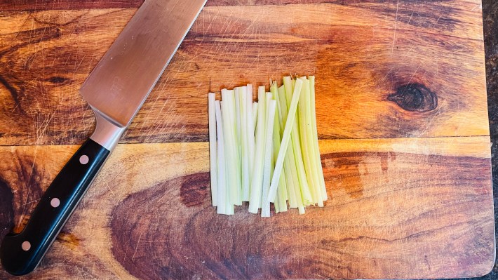 Thin strips of celery on a cutting board