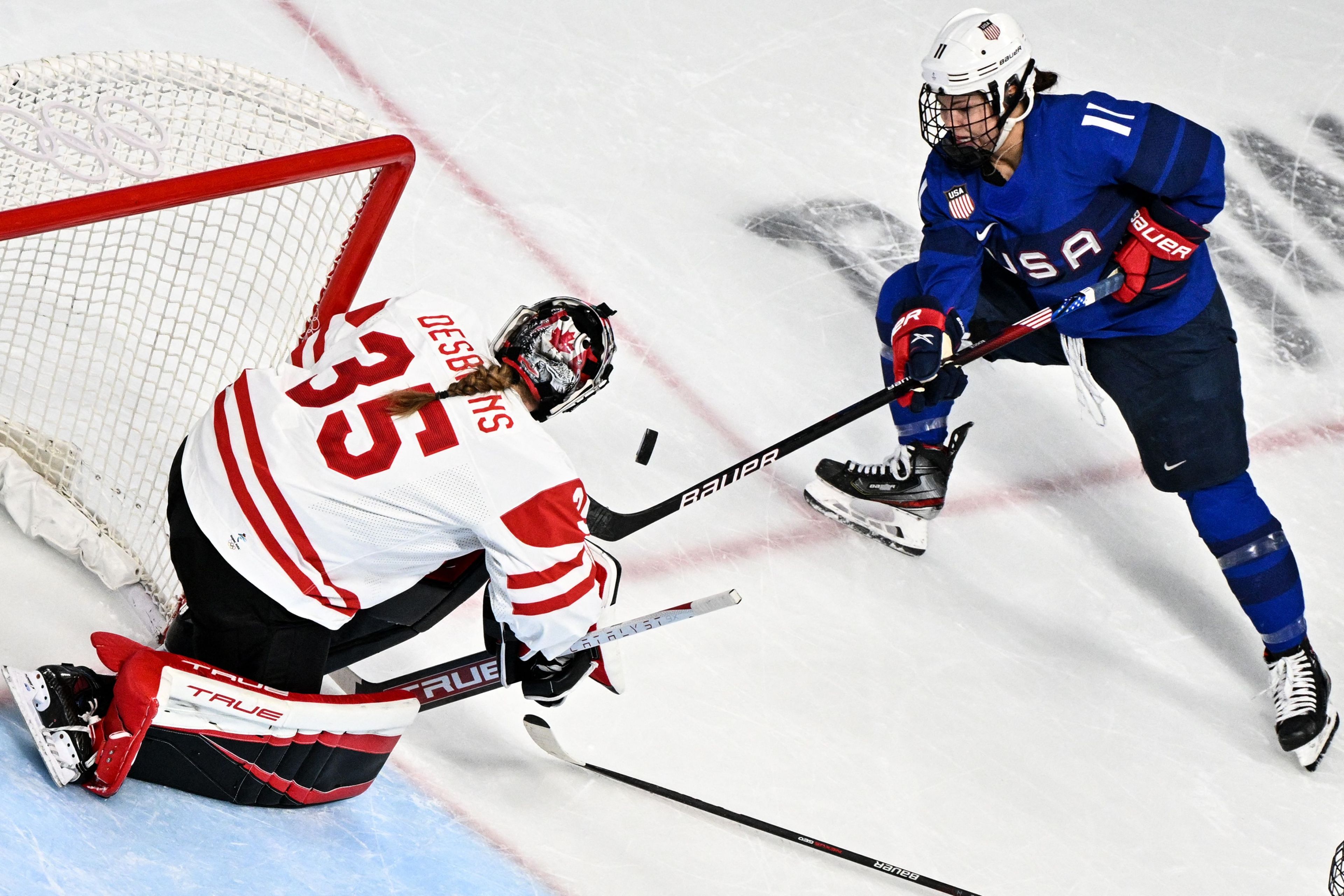 USA's Abby Roque (R) tries to score past USA's goaltender Madeline Rooney during the women's preliminary round group A match of the Beijing 2022 Winter Olympic Games ice hockey competition between USA and Canada, at the Wukesong Sports Centre in Beijing on February 8, 2022.