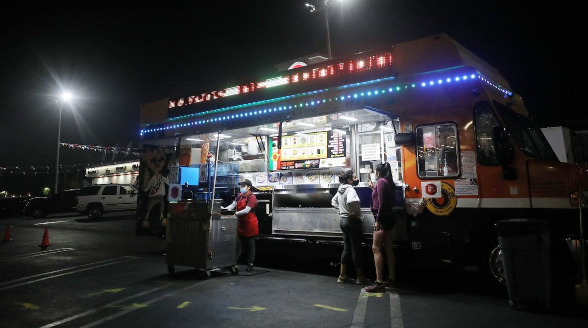 LOS ANGELES, CALIFORNIA - JULY 01: Customers order from a taco truck amid the COVID-19 pandemic on July 1, 2020 in Los Angeles, California. California Governor Gavin Newsom ordered indoor dining restaurants to close again today in Los Angeles County and 18 other counties for at least three weeks amid a surge in new coronavirus cases. Restaurants and food trucks may remain open for takeout and drive-through orders. (Photo by Mario Tama/Getty Images)