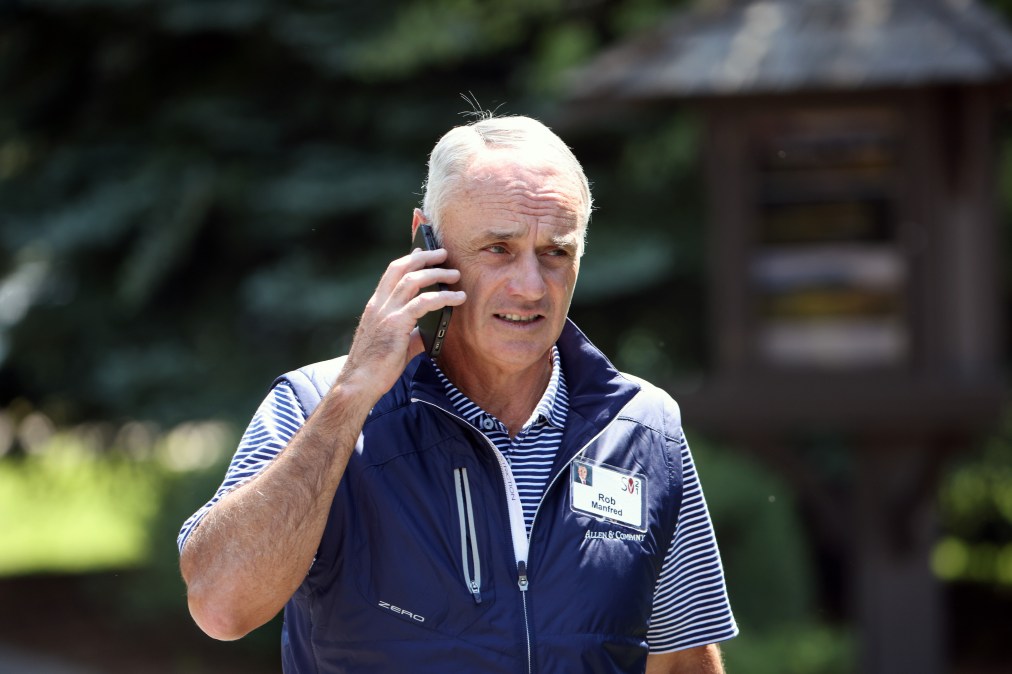 Rob Manfred, seen here perhaps inevitably wearing a vest and talking on the phone.
