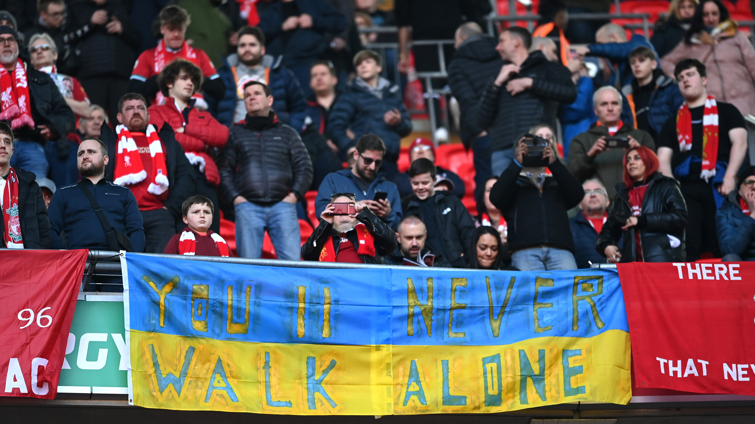 Liverpool fans show a Ukrainian flag to indicate peace and sympathy with Ukraine prior to the Carabao Cup Final match between Chelsea and Liverpool at Wembley Stadium on February 27, 2022 in London, England