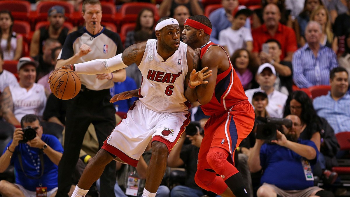 LeBron James posts up Josh Smith in an NBA game.
