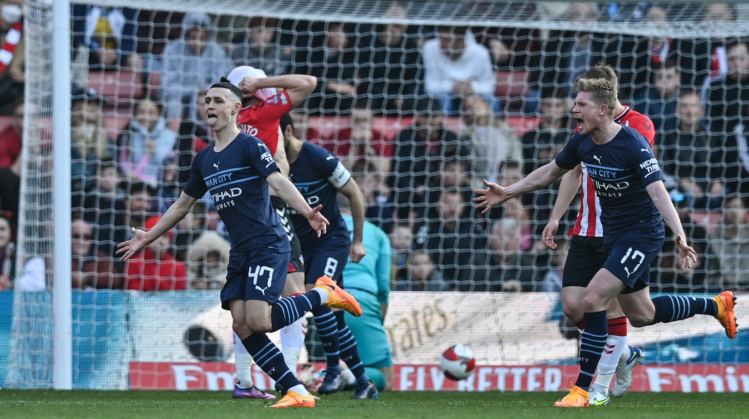 Manchester City's English midfielder Phil Foden (L) celebrates with teammates after scoring his team third goal during the English FA cup quarter-final football match between Southampton and Manchester City at St Mary's Stadium in Southampton, Southern England on March 20, 2022.