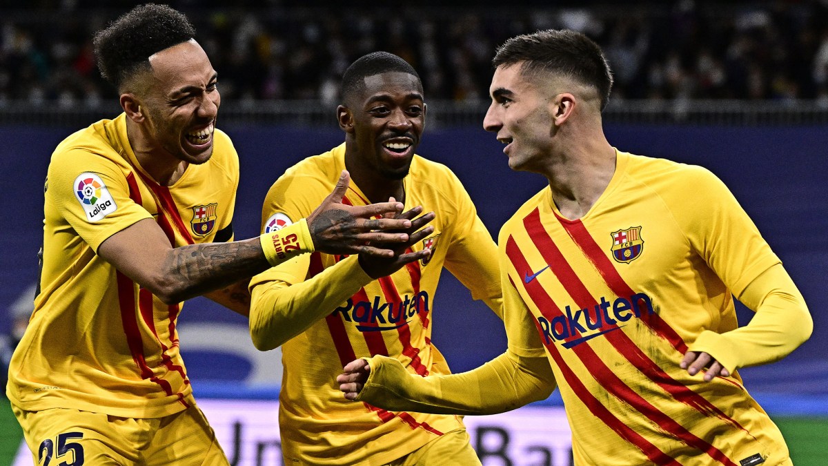 Barcelona's Spanish forward Ferran Torres (R) celebrates with Barcelona's Gabonese midfielder Pierre-Emerick Aubameyang (L) and Barcelona's French forward Ousmane Dembele (C) after scoring a goal during the Spanish League football match between Real Madrid CF and FC Barcelona at the Santiago Bernabeu stadium in Madrid on March 20, 2022. (