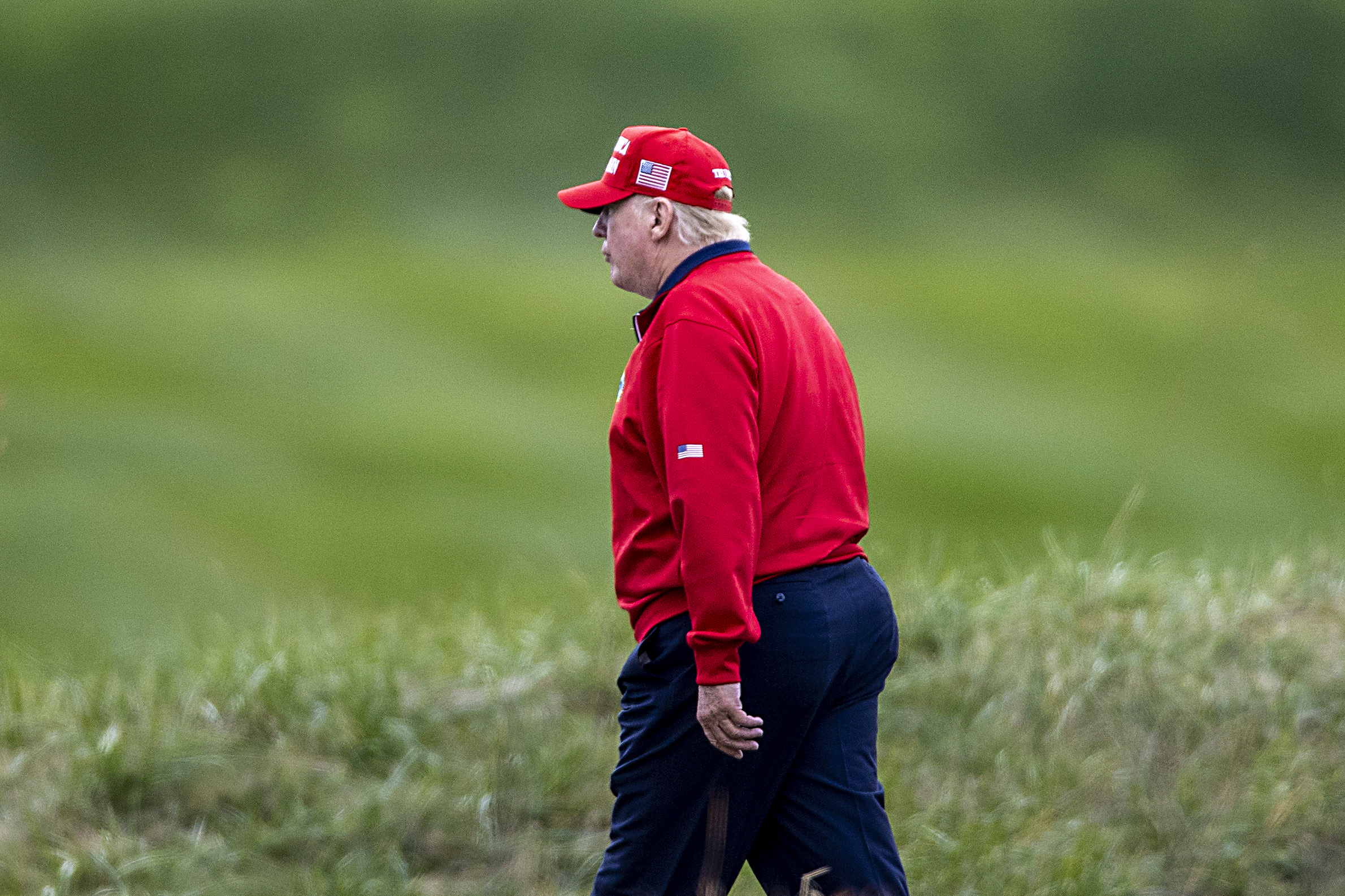 Donald Trump walks very normally towards a helicopter at Trump National Golf Club in November of 2020.