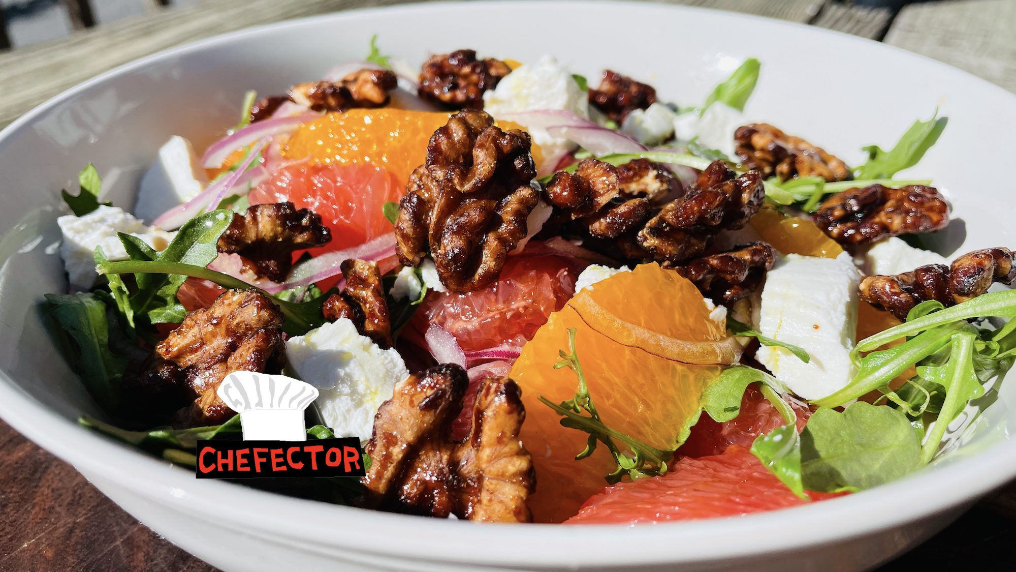 A salad with oranges, grapefruit, walnuts, and goat cheese