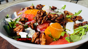 A salad with oranges, grapefruit, walnuts, and goat cheese
