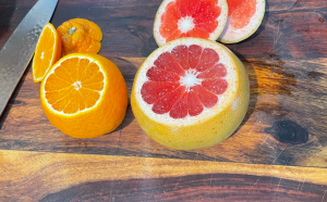 An orange and a grapefruit, partially sliced.