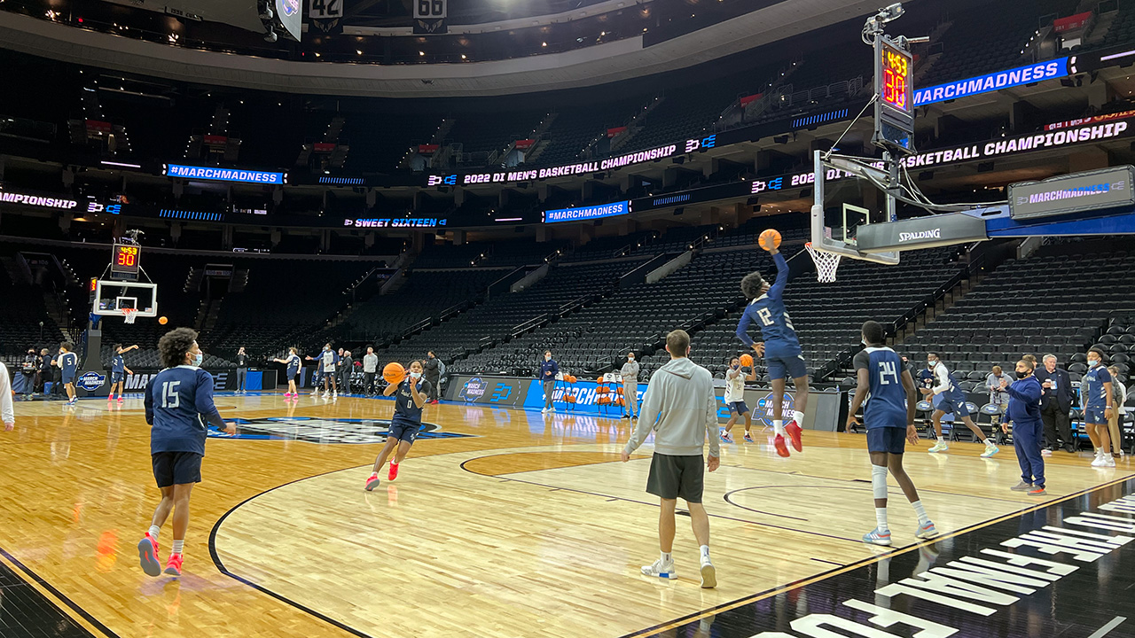 Wide shot, basketball court, player dunking, other players watching and practicing