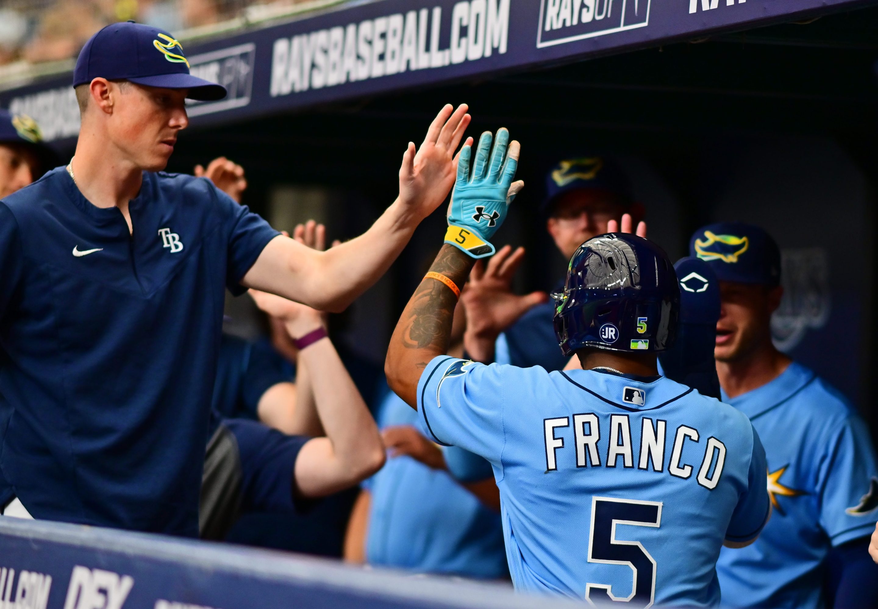 Wander Franco receives congratulations in the dugout after scoring against the Orioles.