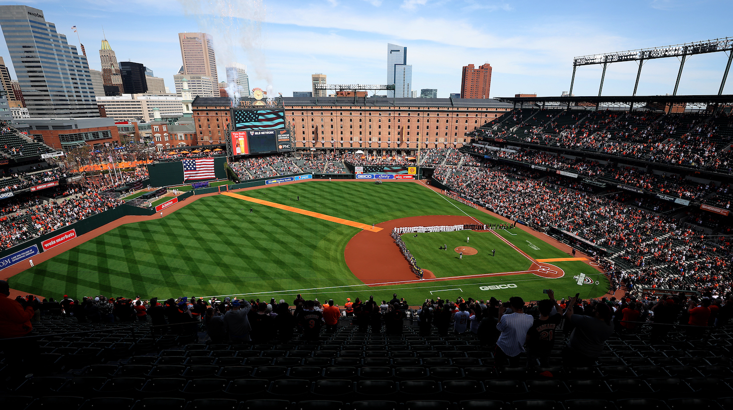 BALTIMORE, MARYLAND - APRIL 11: Members of the Milwaukee Brewers and Baltimore Orioles listen to the national anthem before the start of Opening Day at Oriole Park at Camden Yards on April 11, 2022 in Baltimore, Maryland. (Photo by Rob Carr/Getty Images)