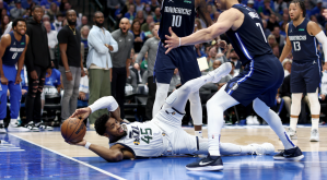 Donovan Mitchell of the Utah Jazz tries to pass the ball while laid out on the floor against the Dallas Mavericks