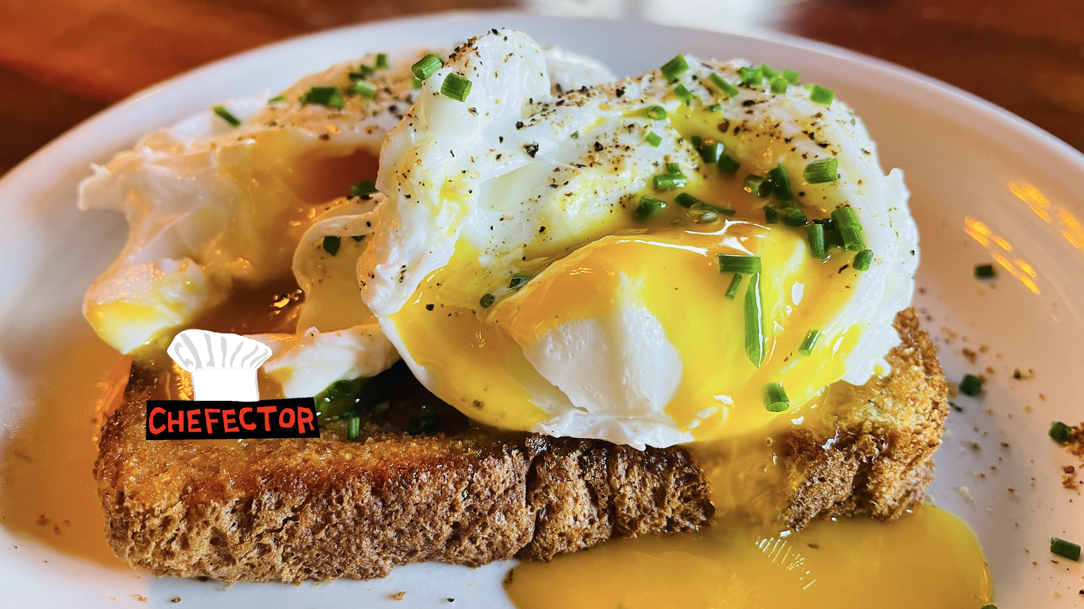 A pair of poached eggs, on toast, with chives