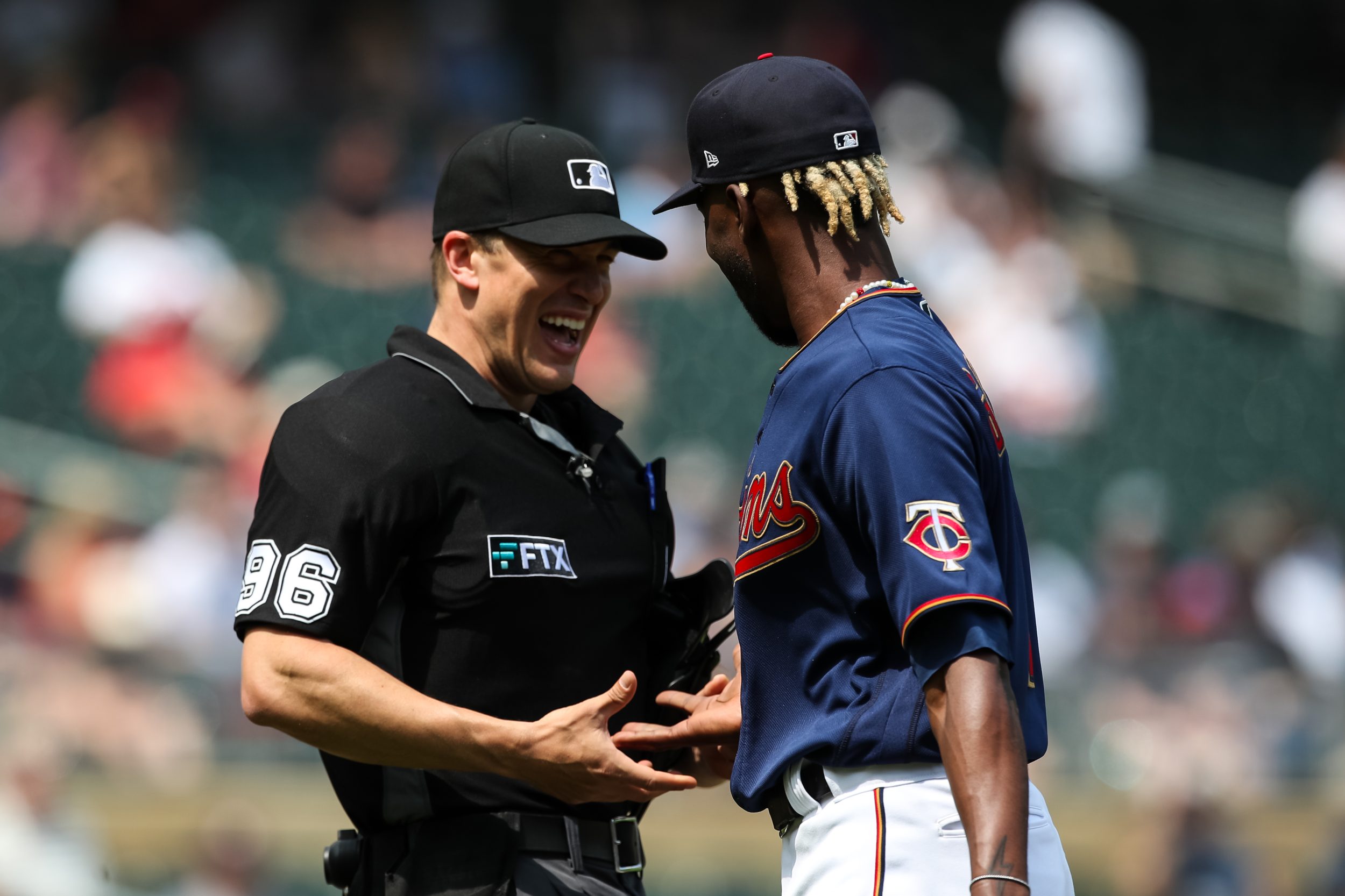 Umpire Chris Segal #96 laughs as he checks the throwing hand of Nick Gordon #1 of the Minnesota Twins for foreign substances.