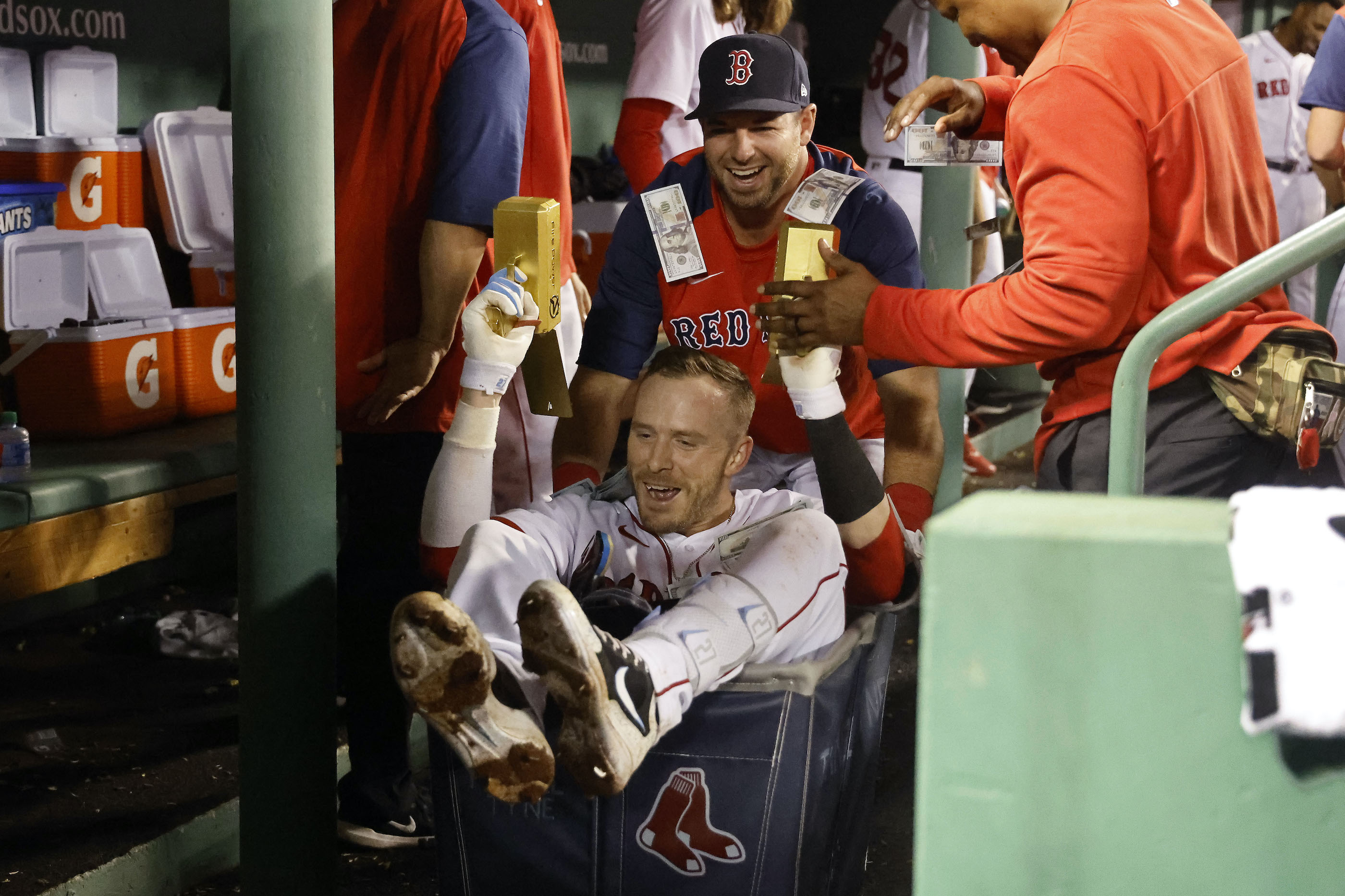 Trevor Story #10 of the Boston Red Sox holds toy money guns as he gets a ride in a laundry cart after his home run against the Houston Astros in the seventh inning at Fenway Park on May 16, 2022 in Boston, Massachusetts.