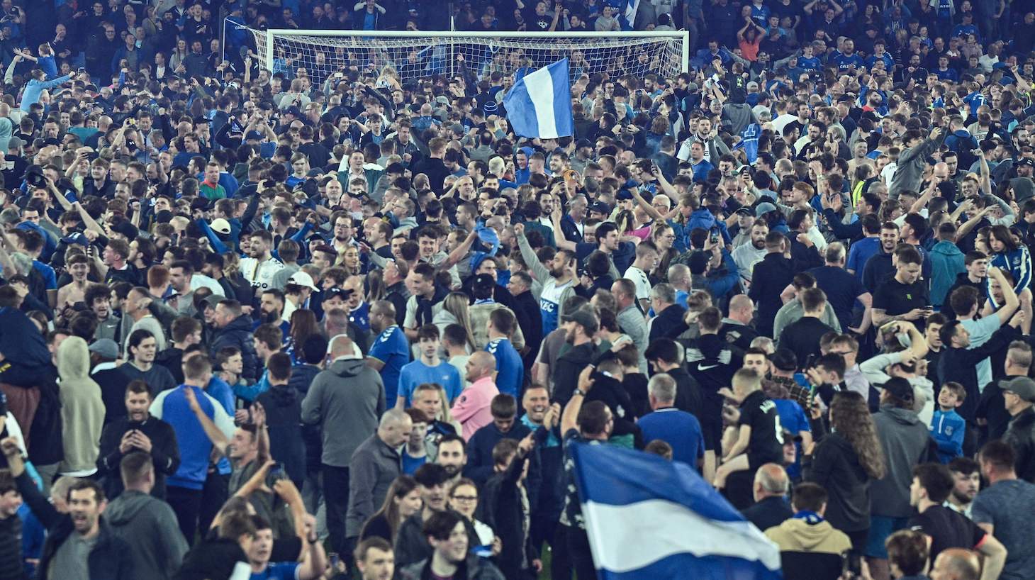 Everton's fans invade the football pitch to celebrate at the end of the English Premier League football match between Everton and Crystal Palace at Goodison Park in Liverpool, north west England on May 19, 2022. - Everton staged a dramatic fightback from two goals down to preserve their Premier League status with a 3-2 win against Crystal Palace.