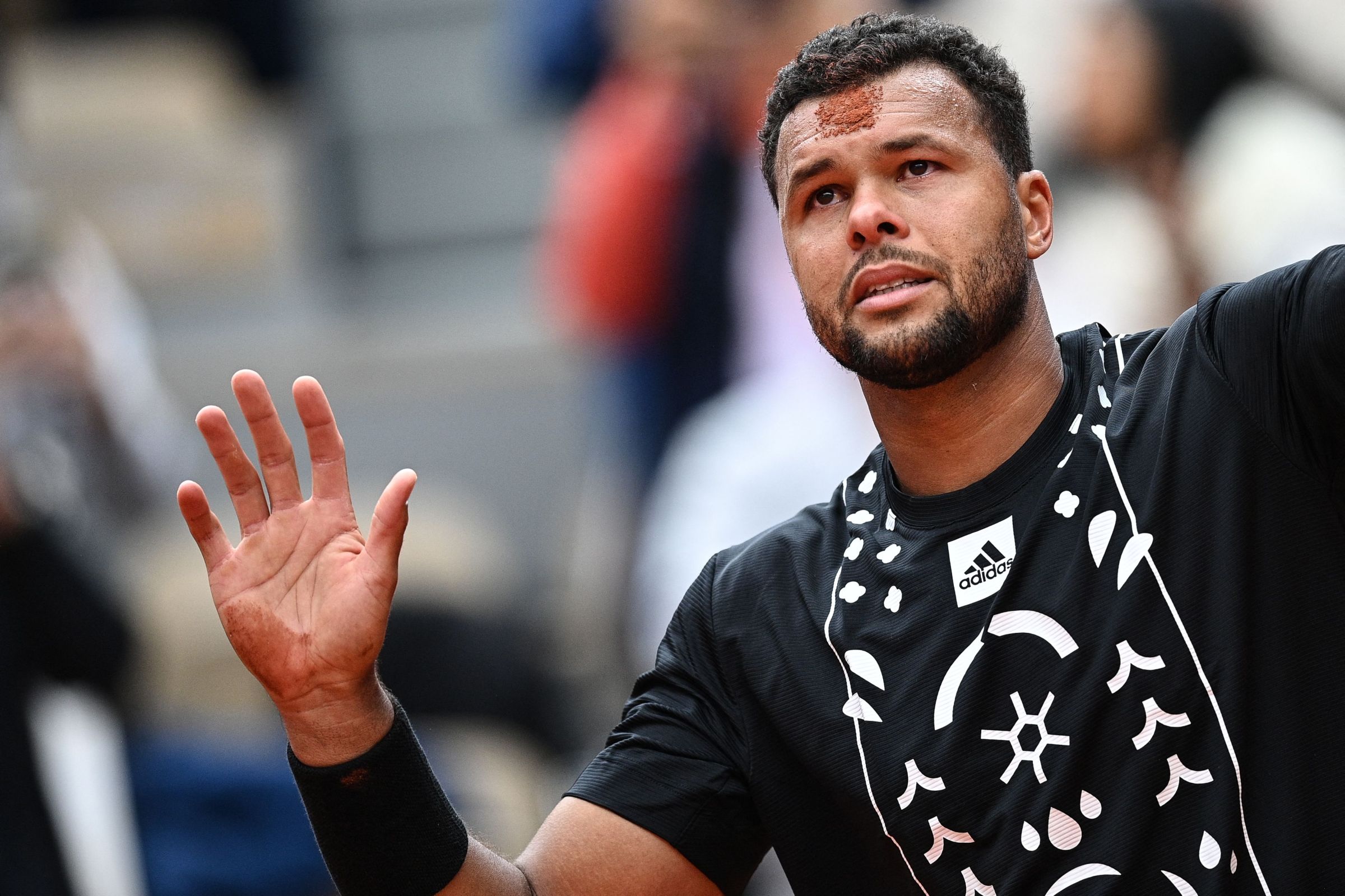 Jo-Wilfried Tsonga salutes the crowd as he retires at the French Open.