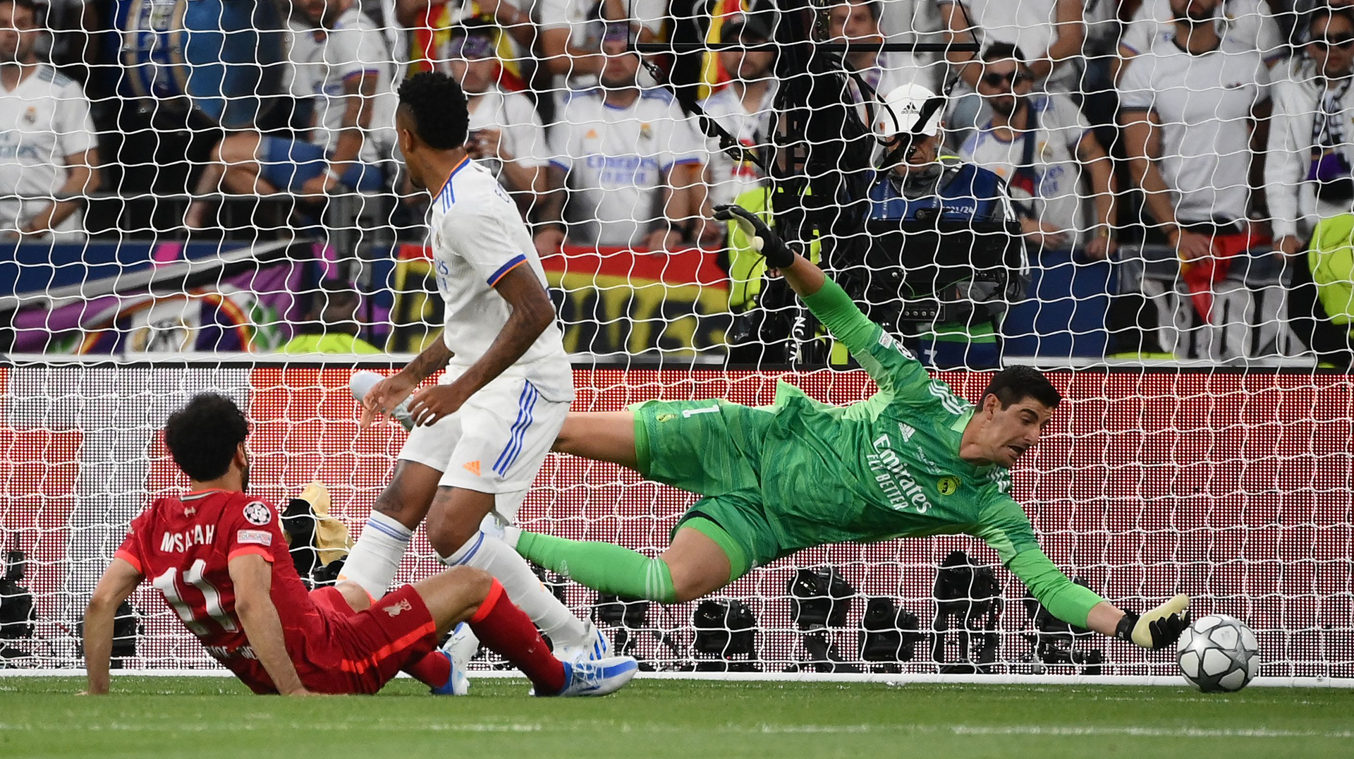 Real Madrid's Belgian goalkeeper Thibaut Courtois (R) makes a save from an attempt by Liverpool's Egyptian midfielder Mohamed Salah (L) during the UEFA Champions League final football match between Liverpool and Real Madrid at the Stade de France in Saint-Denis, north of Paris, on May 28, 2022.