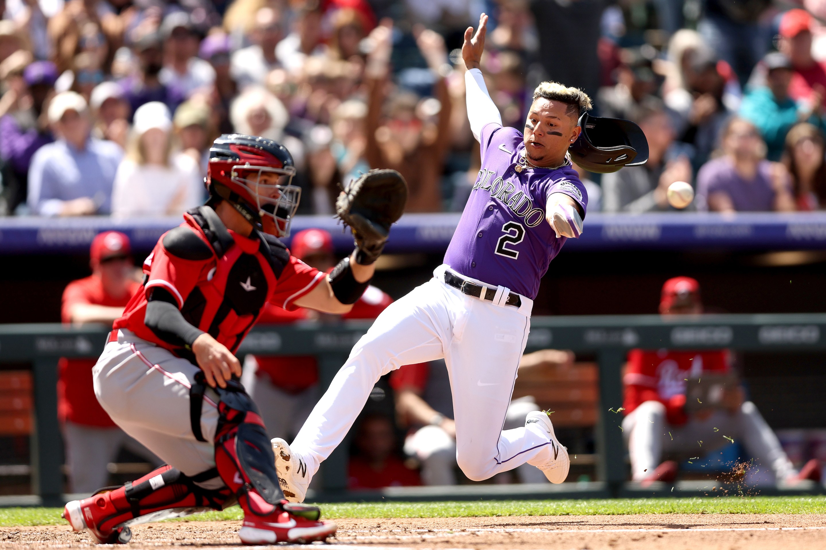 Rockies outfielder Yonathan Daza slides past Reds catcher Mark Kolozsvary in a 10-1 Rockies win.