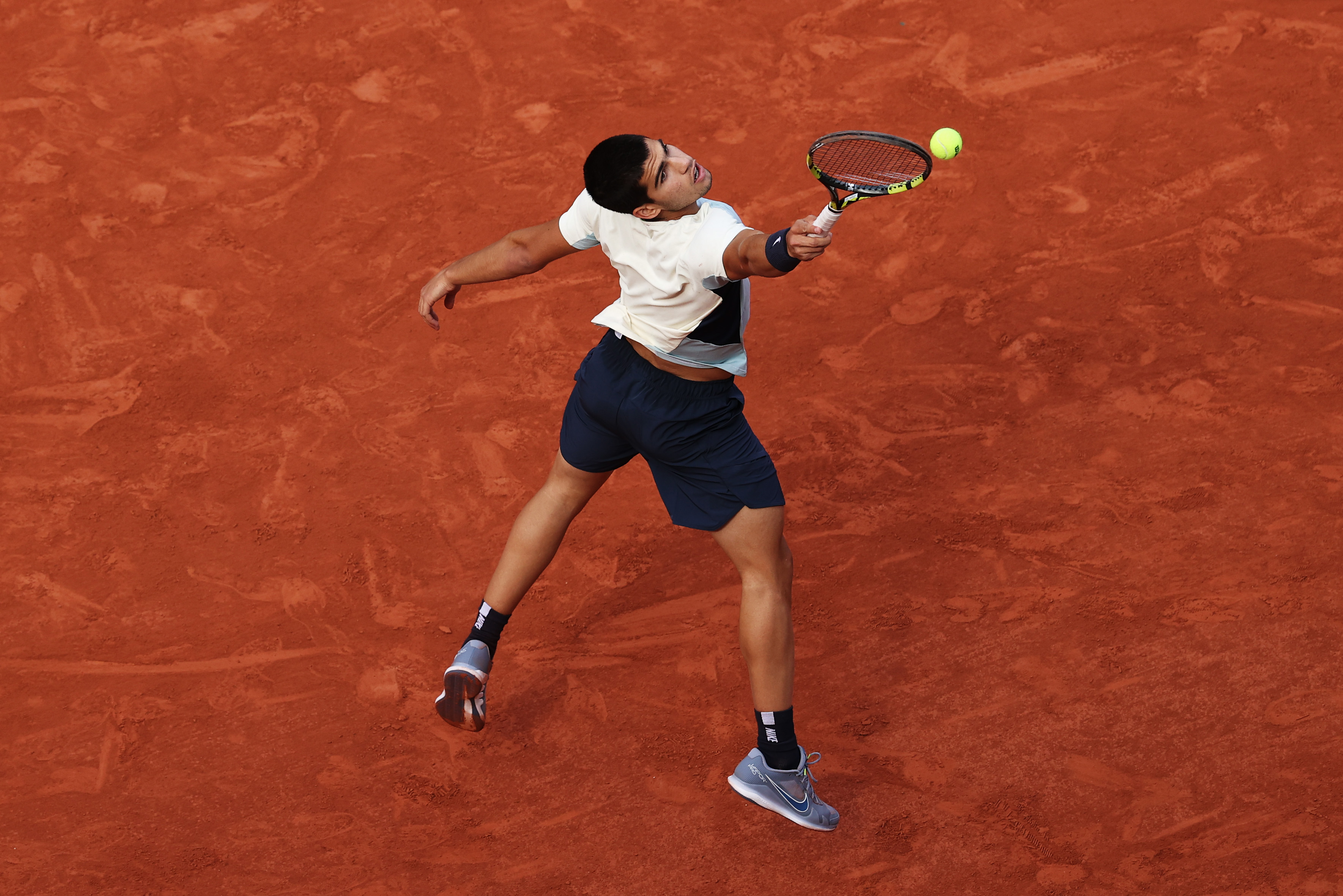Carlos Alcaraz stretches to play a shot.