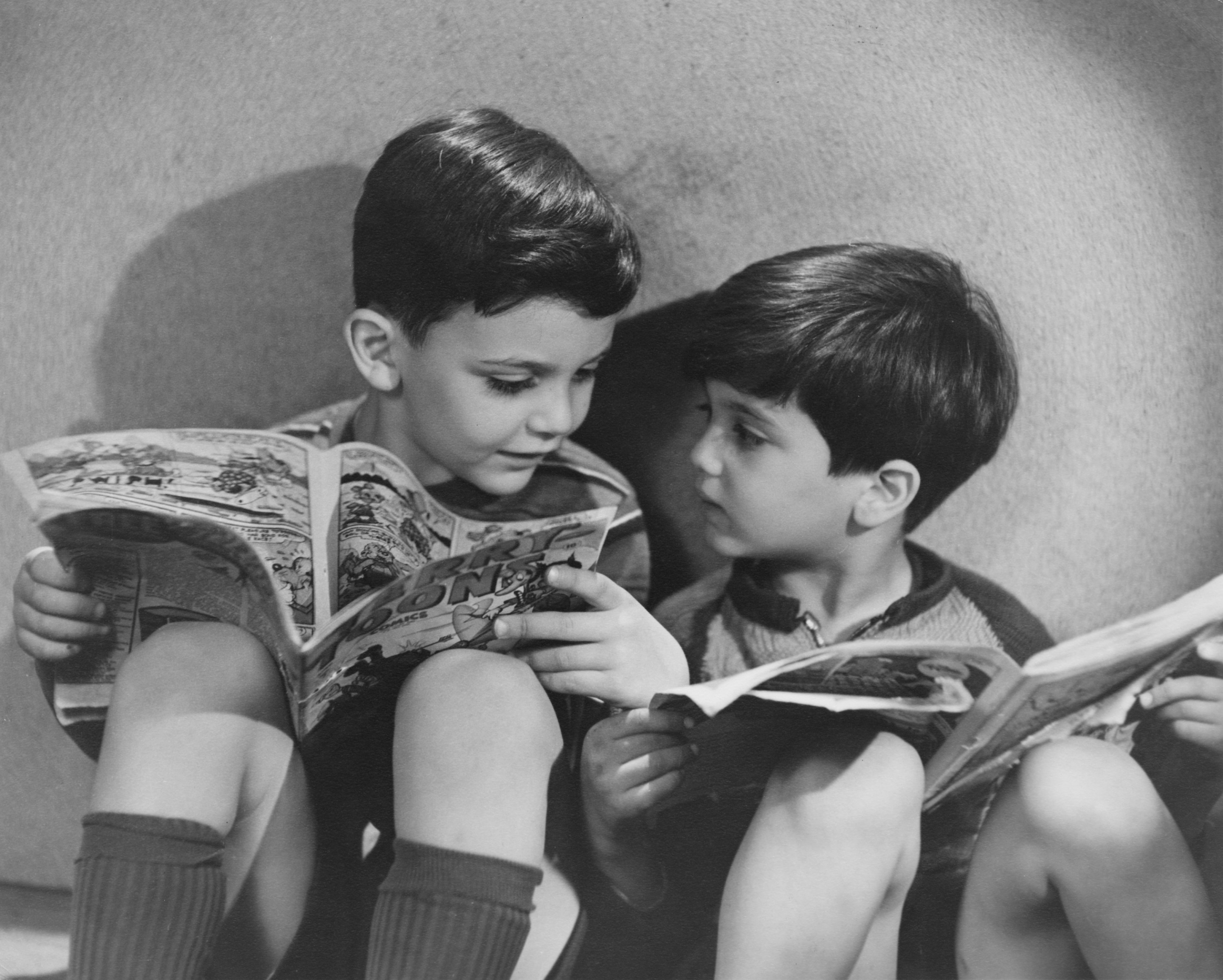 Two boys reading comics, circa 1950.