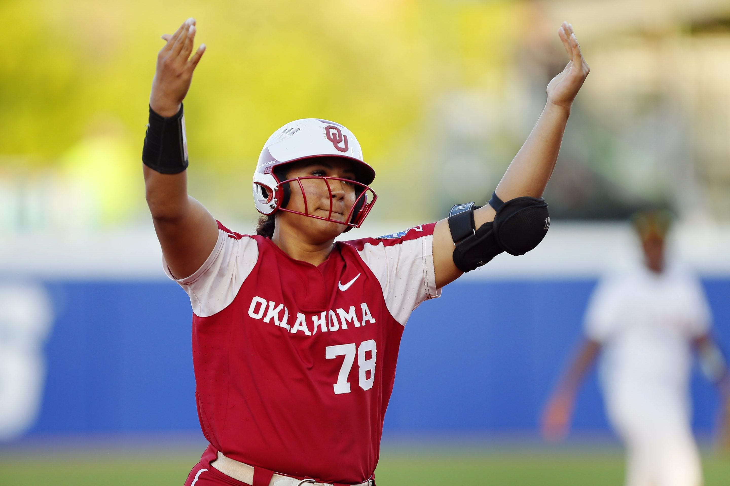 Jocelyn Alo #78 of the Oklahoma Sooners throws her hands in the air after a softball play.