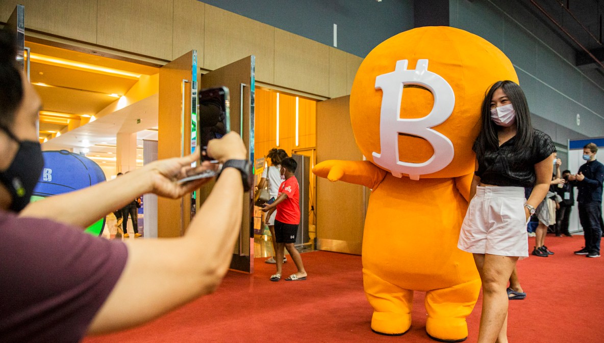 BANGKOK, THAILAND - MAY 14: A woman poses with a Bitcoin mascot during the Thailand Crypto Expo 2022 on May 14, 2022 in Bangkok, Thailand. Cryptocurrency Enthusiasts attend Thailand Crypto Expo 2022, the largest cryptocurrency exposition in Southeast Asia, at the Bangkok International Trade and Exhibition Center. Visitors learn about blockchain projects, exchanges, mining, NFT production, and gamefi technology. The exposition comes during a global market crash. (Photo by Lauren DeCicca/Getty Images)