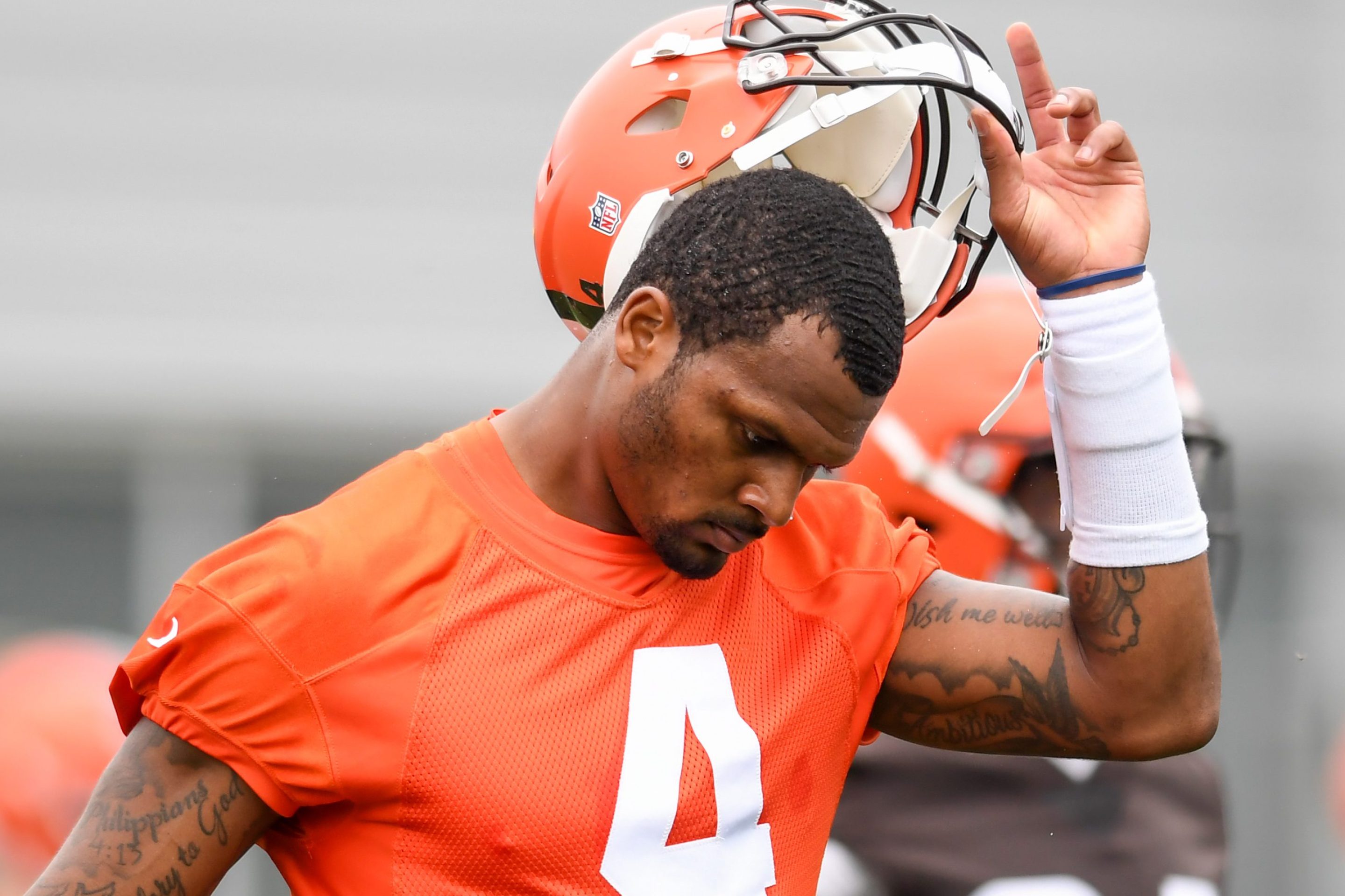 Deshaun Watson #4 of the Cleveland Browns takes off his helmet as he warms up during the Cleveland Browns mandatory minicamp at CrossCountry Mortgage Campus on June 14, 2022 in Berea, Ohio.