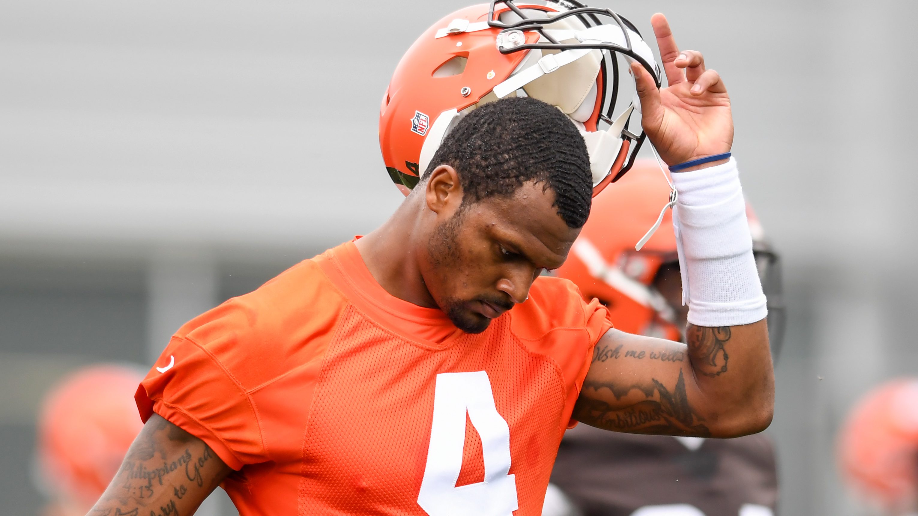 Deshaun Watson #4 of the Cleveland Browns takes off his helmet as he warms up during the Cleveland Browns mandatory minicamp at CrossCountry Mortgage Campus on June 14, 2022 in Berea, Ohio.
