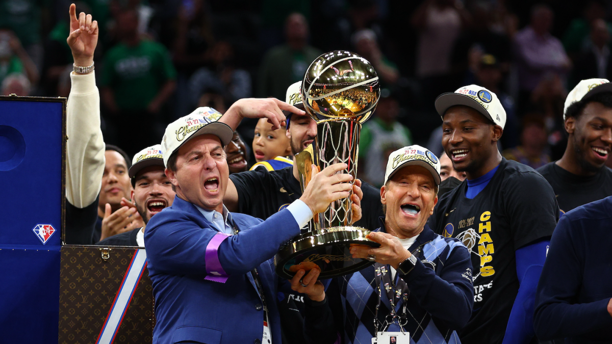Warriors owners Joe Lacob and Peter Guber hoist the Larry O'Brien NBA championship trophy