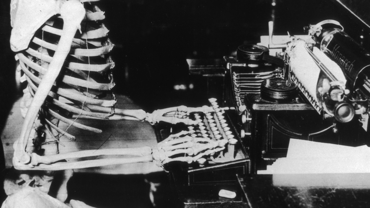 A skeleton sits at a typewriter