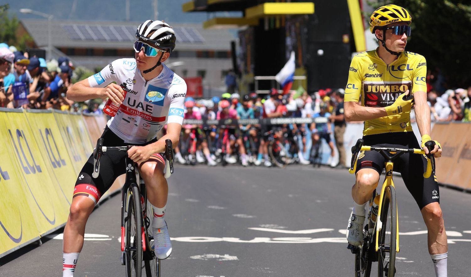 Jumbo-Visma team's Danish rider Jonas Vingegaard wearing the overall leader's yellow jersey (R) and UAE Team Emirates team's Slovenian rider Tadej Pogacar wearing the best young rider's white jersey (L) await the start of the 13th stage of the 109th edition of the Tour de France cycling race, 192,6 km between Le Bourg d'Oisans in the French Alps, and Saint-Etienne in central France, on July 15, 2022. (Photo by Thomas SAMSON / AFP) (Photo by THOMAS SAMSON/AFP via Getty Images)
