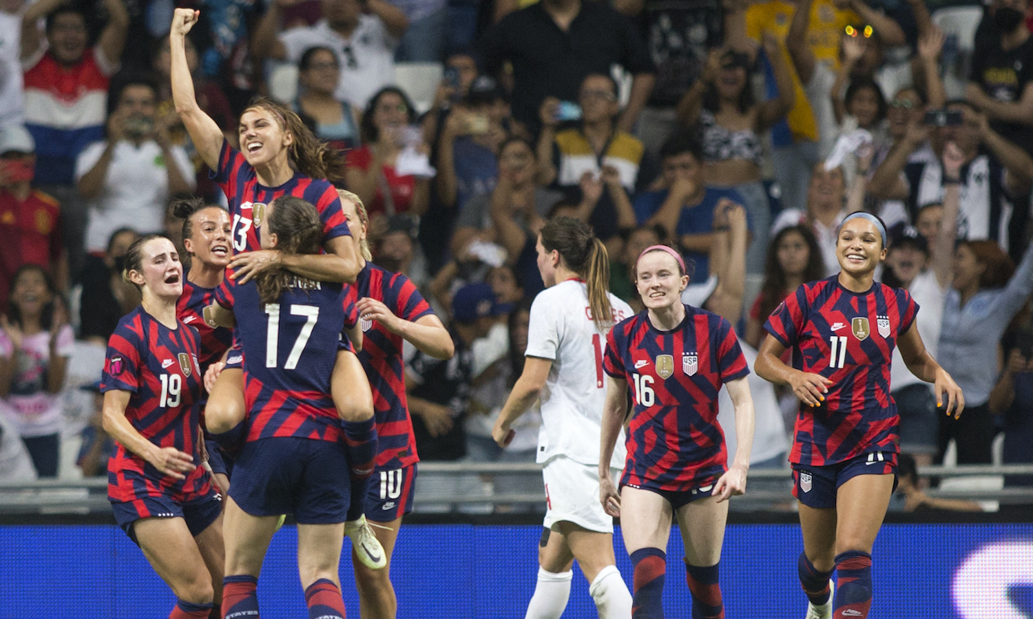 USA's Alex Morgan (top) celebrates with teammates after scoring against Canada during their 2022 Concacaf women's championship final football match, at the BBVA Bancomer stadium in Monterrey, Nuevo Leon State, Mexico on July 18, 2022. (Photo by Julio Cesar AGUILAR / AFP) (Photo by JULIO CESAR AGUILAR/AFP via Getty Images)