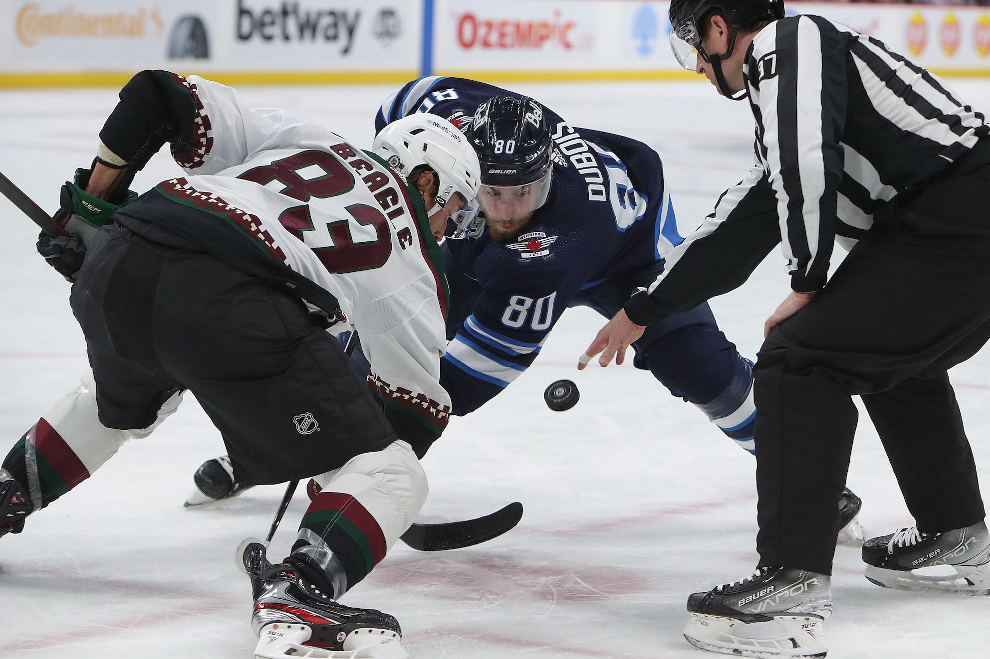WINNIPEG, MANITOBA - MARCH 27: Jay Beagle #83 of the Arizona Coyotes faces off with Pierre-Luc Dubois #80 of the Winnipeg Jets in the second period during a game on March 27, 2022 at Canada Life Centre in Winnipeg, Manitoba, Canada. (Photo by Jason Halstead/Getty Images)