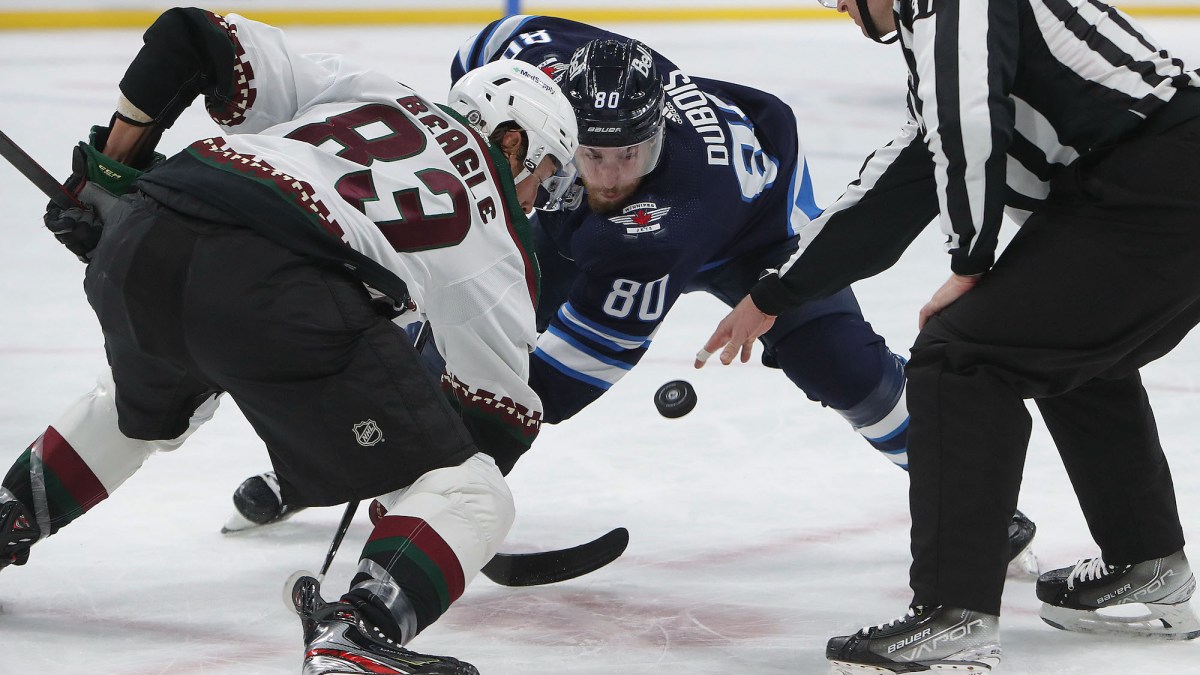 WINNIPEG, MANITOBA - MARCH 27: Jay Beagle #83 of the Arizona Coyotes faces off with Pierre-Luc Dubois #80 of the Winnipeg Jets in the second period during a game on March 27, 2022 at Canada Life Centre in Winnipeg, Manitoba, Canada. (Photo by Jason Halstead/Getty Images)