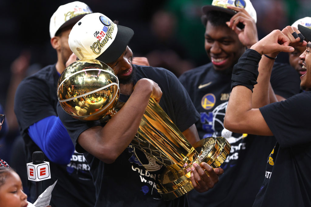 Andrew Wiggins cradles the Warriors championship trophy.