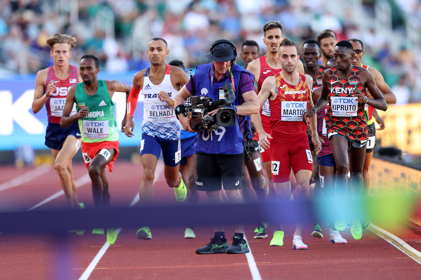 EUGENE, OREGON - JULY 18: Athletes in the Men's 3000m Steeplechase Final run around a cameraman on the track on day four of the World Athletics Championships Oregon22 at Hayward Field on July 18, 2022 in Eugene, Oregon. (Photo by Patrick Smith/Getty Images)