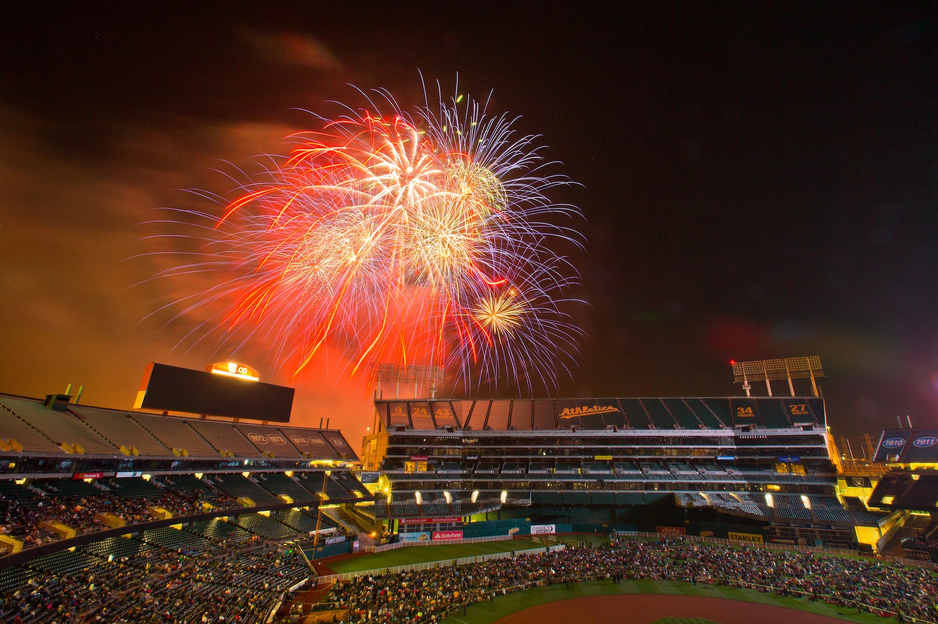 OAKLAND, CA - JUNE 19: Fans crowd onto the field for fireworks after a game between the Oakland Athletics and the Los Angeles Angels of Anaheim at O.co Coliseum on June 19, 2015 in Oakland, California. The Angels won 12-7. (Photo by Brian Bahr/Getty Images)
